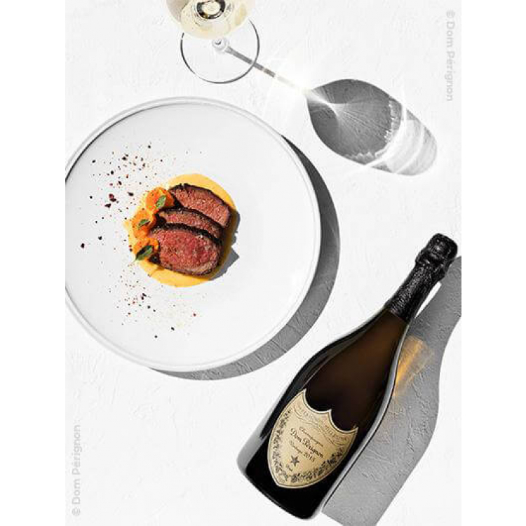 une bouteille de dom perignon vintage 2013 à table avec un plat gastronomique et un verre de champagne
