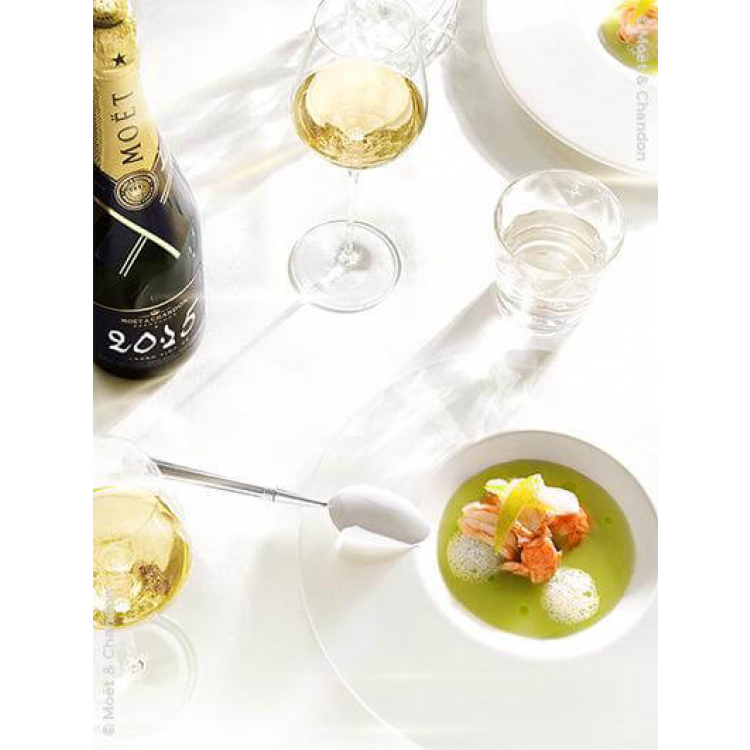 bouteille de moet et chandon grand vintage 2015 75cl sur une table avec une soupe et 2 verres