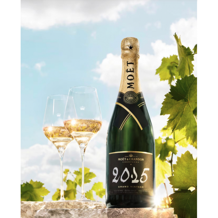 bouteille de moet et chandon grand vintage 2015 75cl au milieu des vignes avec deux verres